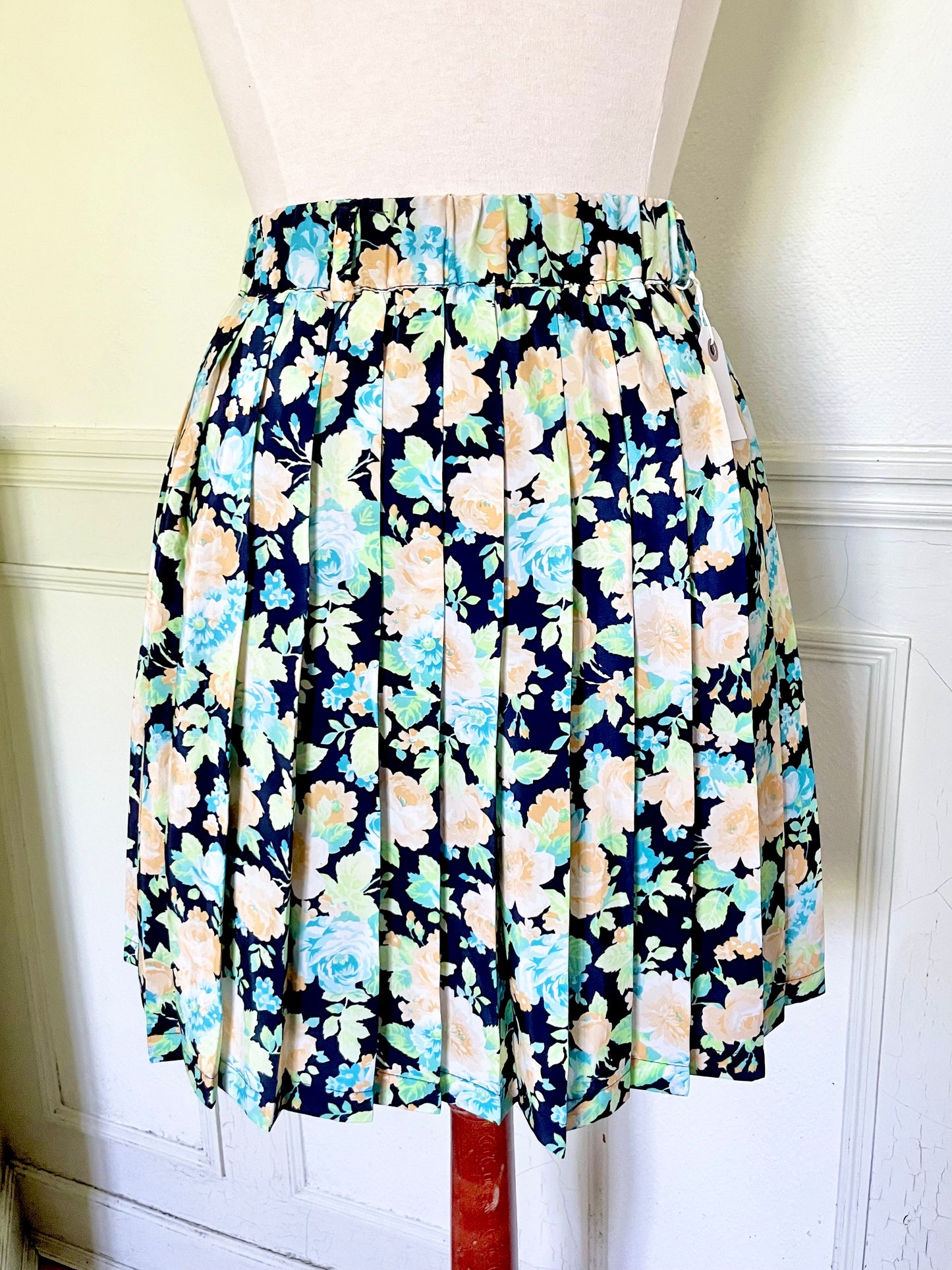 Jupe fleurie plissée bleue, verte et orange pastel